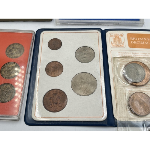 2323 - Four coin sets to include 'Britain's First Decimal Coins', Royal Mint 1977 etc. together with empty ... 