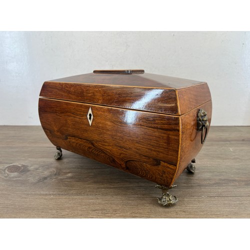 594 - A George III inlaid rosewood sarcophagus tea caddy with brass lion paw handles, mythical fish feet a... 