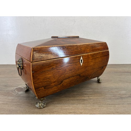 594 - A George III inlaid rosewood sarcophagus tea caddy with brass lion paw handles, mythical fish feet a... 