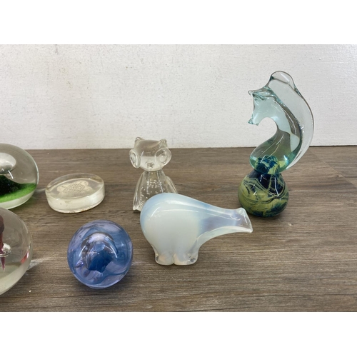 403 - A collection of art glass and Lucite paperweights to include Caithness, Mdina seahorse etc.