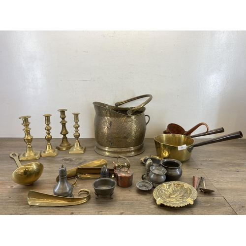 451 - A collection of antique and later metalware to include two 19th century brass graduating saucepans, ... 