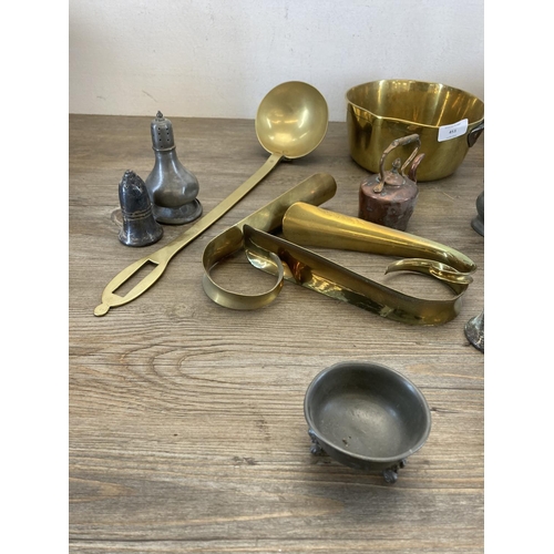 451 - A collection of antique and later metalware to include two 19th century brass graduating saucepans, ... 