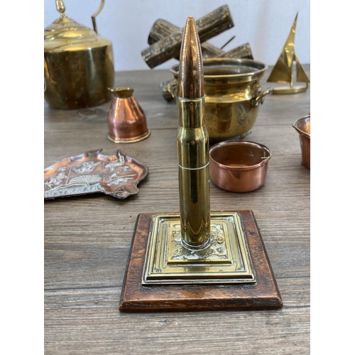 453 - A collection of vintage brass and copperware to include brass bullet desk ornament, brass log splitt... 