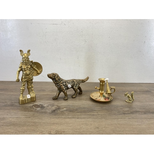 464 - Four pieces of brassware, cast dog figurine, Viking figurine, squirrel ornament and chamberstick