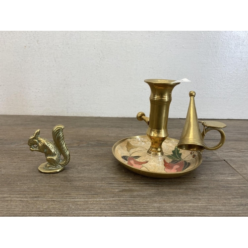 464 - Four pieces of brassware, cast dog figurine, Viking figurine, squirrel ornament and chamberstick