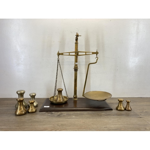 519 - A set of 19th century brass balance scales on stained mahogany base - approx. 59cm high x 53cm wide ... 