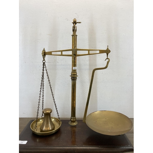 519 - A set of 19th century brass balance scales on stained mahogany base - approx. 59cm high x 53cm wide ... 