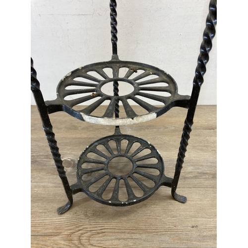 520 - Two wrought iron items, one black painted four tier kitchen pan stand - approx. 77cm high and one 19... 