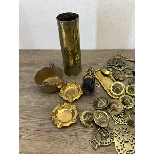 536 - A collection of 19th century and later brassware to include horse brasses, shell case, fire poker et... 