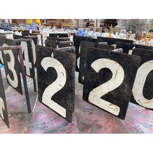 551 - Twenty three vintage hand-painted on steel cricket numbers on bespoke wrought iron stands - approx. ... 