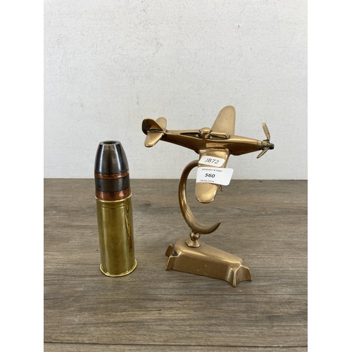 560 - Two items, one handmade brass aeroplane desk ornament and one SV & N brass shell case - approx. 15cm... 