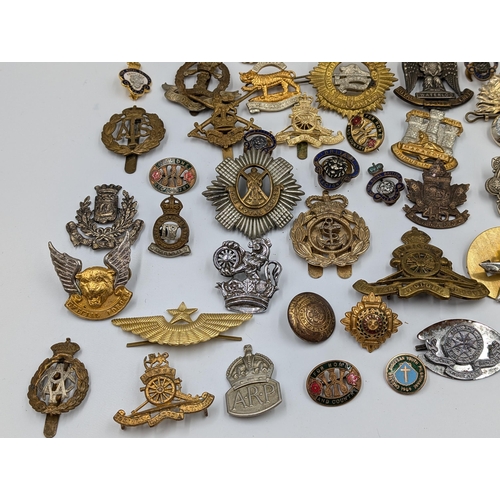 2166 - A large collection of military cap badges