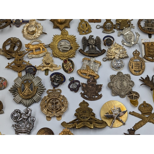 2166 - A large collection of military cap badges