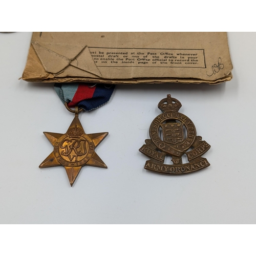 2180 - A WWII British medal trio with soldier's release book and Royal Army Ordnance Corps cap badge