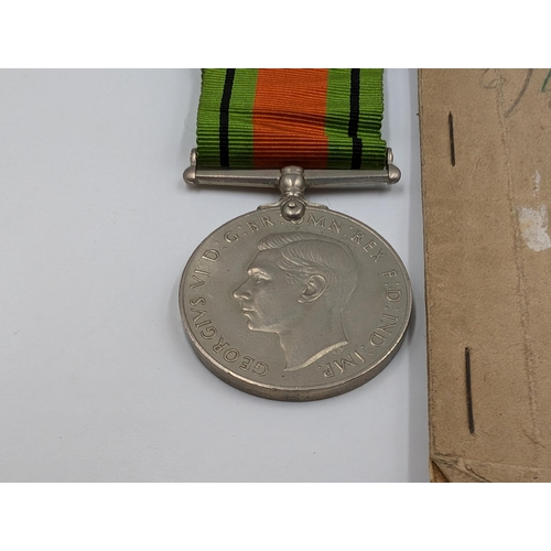 2180 - A WWII British medal trio with soldier's release book and Royal Army Ordnance Corps cap badge