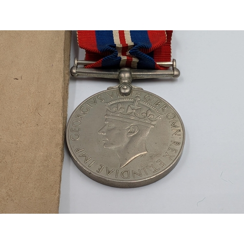 2180 - A WWII British medal trio with soldier's release book and Royal Army Ordnance Corps cap badge