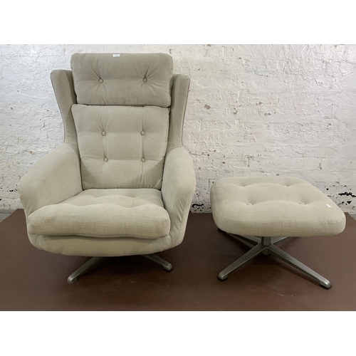 107 - A mid 20th century fabric upholstered swivel armchair and footstool on aluminium base - approx. 103c... 