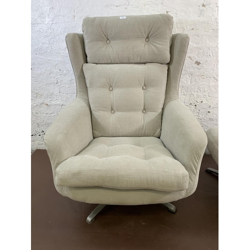 107 - A mid 20th century fabric upholstered swivel armchair and footstool on aluminium base - approx. 103c... 