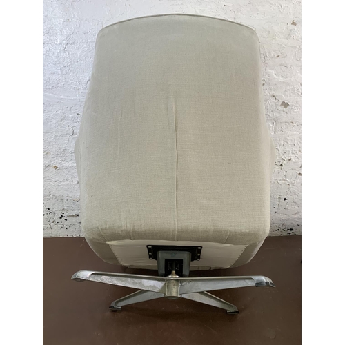 107 - A mid 20th century fabric upholstered swivel armchair and footstool on aluminium base - approx. 103c... 