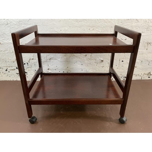 113 - A mid 20th century stained teak two tier tea trolley - approx. 64cm high x 45cm wide x 68cm long