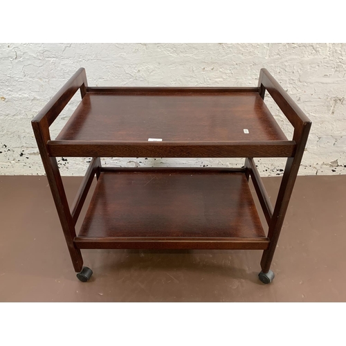 113 - A mid 20th century stained teak two tier tea trolley - approx. 64cm high x 45cm wide x 68cm long