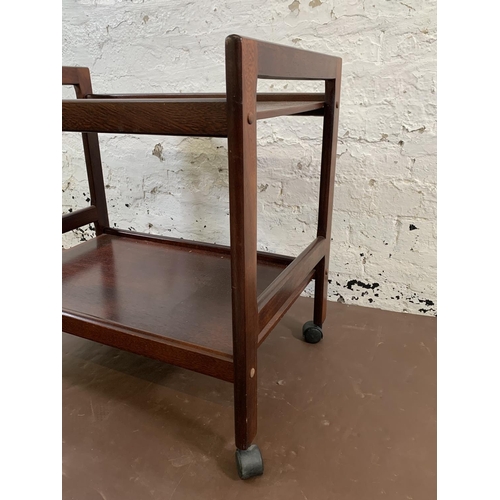 113 - A mid 20th century stained teak two tier tea trolley - approx. 64cm high x 45cm wide x 68cm long