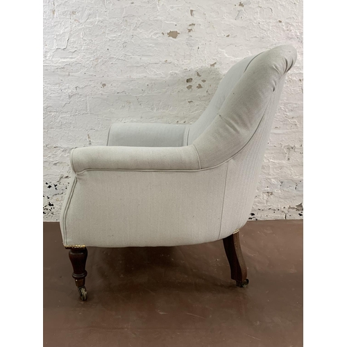 129 - A Victorian button back Saville Row fabric upholstered armchair on rosewood supports and brass casto... 