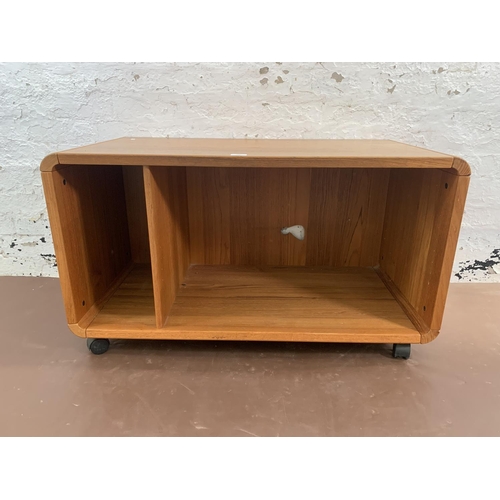 132 - A mid 20th century teak media unit on castors - approx. 58cm high x 100cm wide x 50cm deep