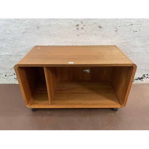 132 - A mid 20th century teak media unit on castors - approx. 58cm high x 100cm wide x 50cm deep