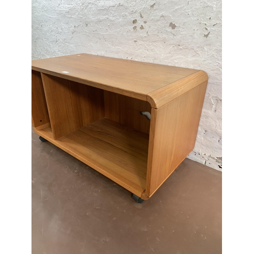 132 - A mid 20th century teak media unit on castors - approx. 58cm high x 100cm wide x 50cm deep