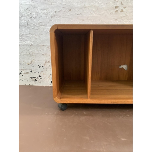 132 - A mid 20th century teak media unit on castors - approx. 58cm high x 100cm wide x 50cm deep