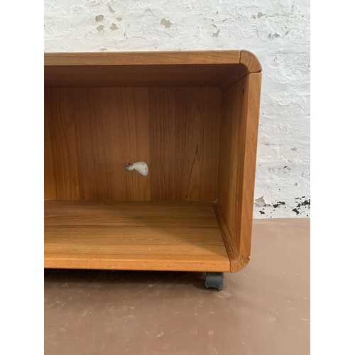 132 - A mid 20th century teak media unit on castors - approx. 58cm high x 100cm wide x 50cm deep