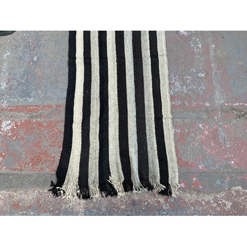 14 - A mid 20th century black and white Kilim hall runner/rug - approx. 245cm x 95cm