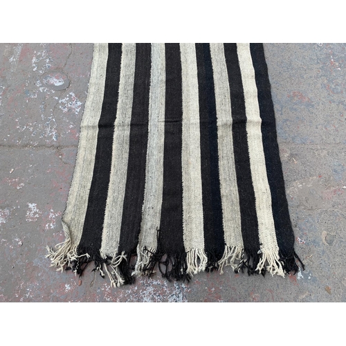 14 - A mid 20th century black and white Kilim hall runner/rug - approx. 245cm x 95cm