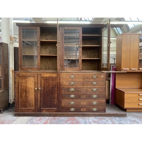 149 - A late 19th/early 20th century oak shop display cabinet with four glazed doors, two lower cupboard d... 