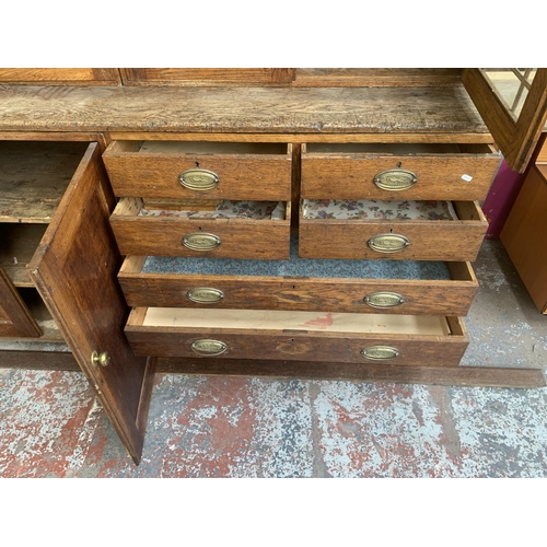 149 - A late 19th/early 20th century oak shop display cabinet with four glazed doors, two lower cupboard d... 