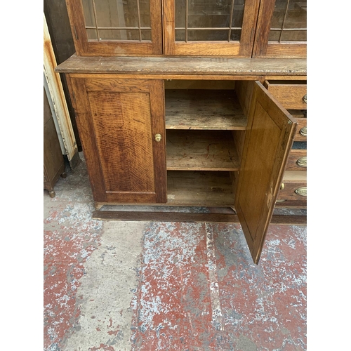 149 - A late 19th/early 20th century oak shop display cabinet with four glazed doors, two lower cupboard d... 