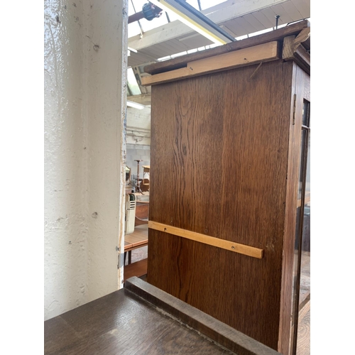 149 - A late 19th/early 20th century oak shop display cabinet with four glazed doors, two lower cupboard d... 