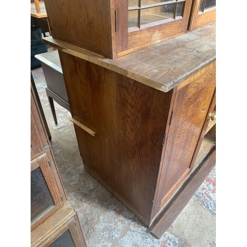 149 - A late 19th/early 20th century oak shop display cabinet with four glazed doors, two lower cupboard d... 