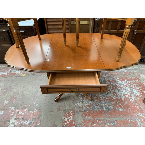 166 - A cherry wood drop leaf pedestal dining table and two carver chairs