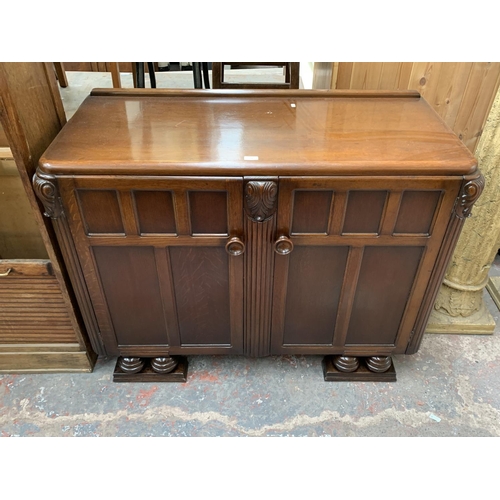 178 - An Art Deco style carved oak sideboard on baluster supports - approx. 95cm high x 122cm wide x 54cm ... 