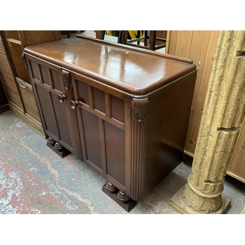 178 - An Art Deco style carved oak sideboard on baluster supports - approx. 95cm high x 122cm wide x 54cm ... 