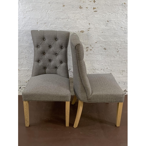 192 - A pair of modern grey button back fabric upholstered dining chairs on oak supports