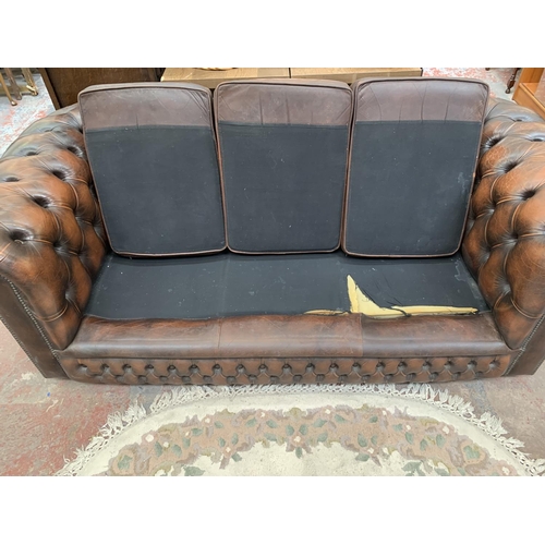 196 - A brown leather Chesterfield three seater sofa - approx. 71cm high x 196cm wide x 94cm deep