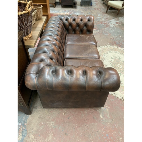 196 - A brown leather Chesterfield three seater sofa - approx. 71cm high x 196cm wide x 94cm deep