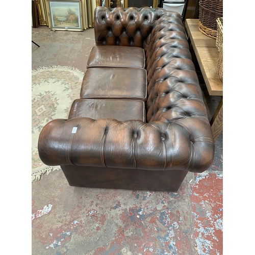196 - A brown leather Chesterfield three seater sofa - approx. 71cm high x 196cm wide x 94cm deep