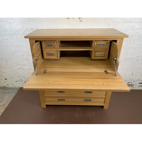 209 - A modern oak secretaire chest of drawers - approx. 114cm high x 111cm wide x 50cm deep