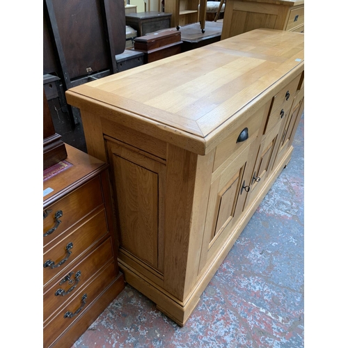 211 - A modern solid oak sideboard - approx. 97cm high x 168cm wide x 50cm deep