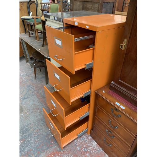 214 - An orange metal four drawer office filing cabinet - approx. 133cm high x 47cm wide x 62cm deep