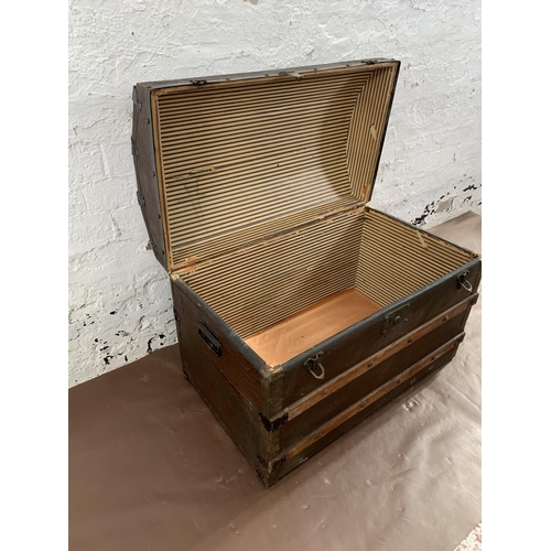 229 - An early 20th century black painted fibreboard and oak banded dome top travel trunk - approx. 55cm h... 